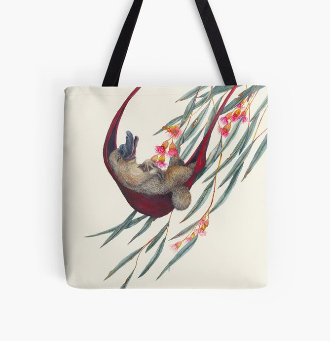 This is a tote bag with the image of a relaxing platypus in a hammock. The image is printed on both sides of the washable cloth bag. There are gum leaves and gum flowers gently moving in the breeze. This image is painted by Patricia (PJ) Hopwood-Wade.